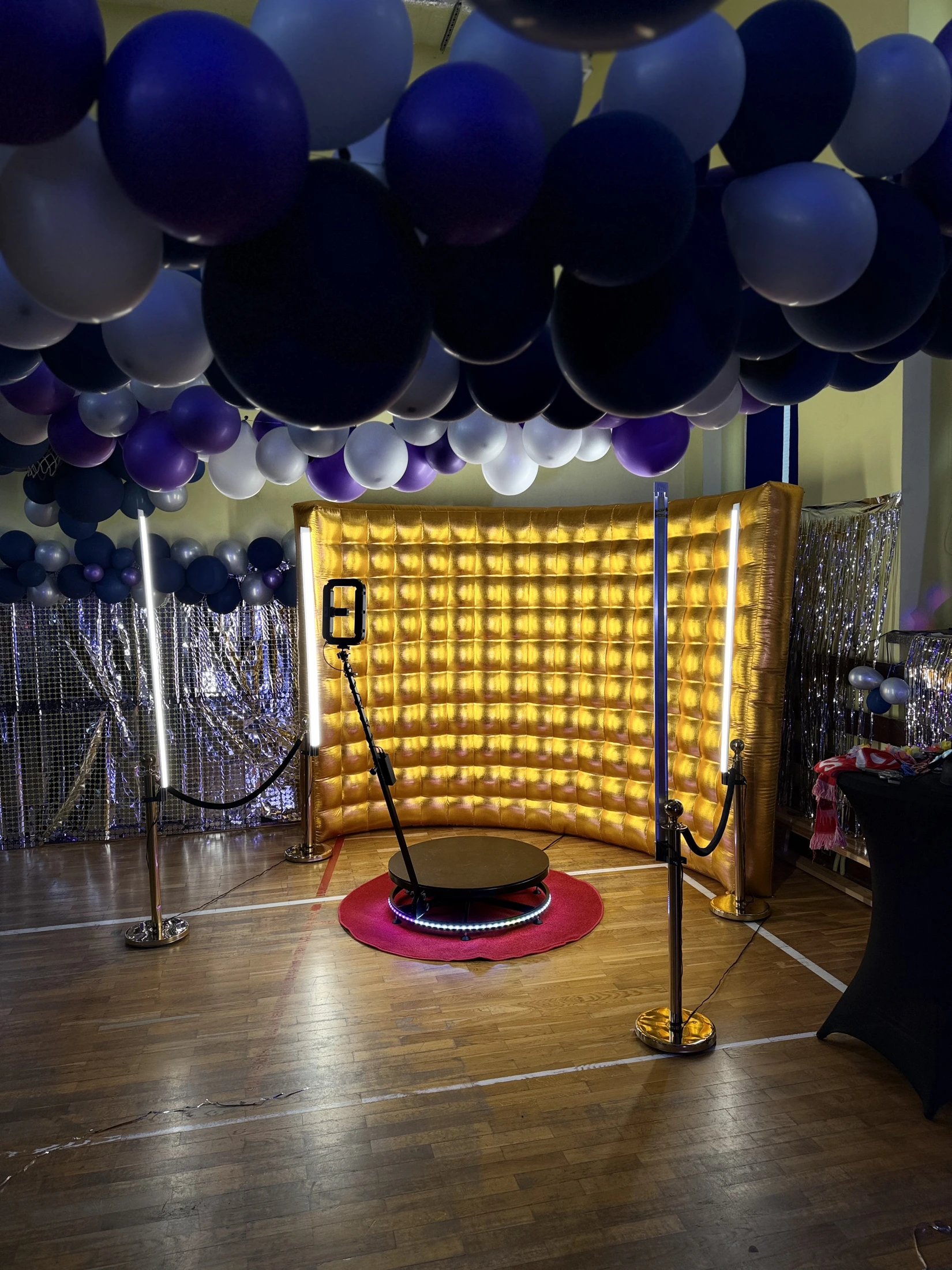 Stanowisko Fotobudki 360 ze złotą ścianką pod dekoracją balonową