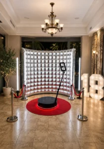 Kompletny zestaw Fotobudki 360 z platformą obrotową, srebrną dmuchaną ścianką, czerwonym dywanem i słupkami VIP podczas eleganckiego eventu.