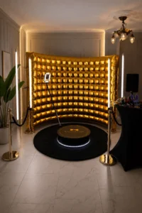 Fotobudka 360 Premium z okrągłą platformą, złotą dmuchaną ścianką, oświetleniem LED, słupkami VIP i rekwizytami na eleganckim evencie.