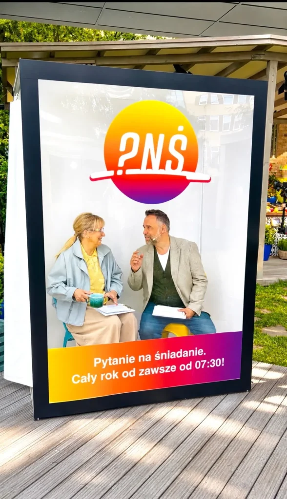 Magazine Photobox z personalizowaną okładką magazynu podczas eventu promocyjnego z prowadzącymi program telewizyjny.